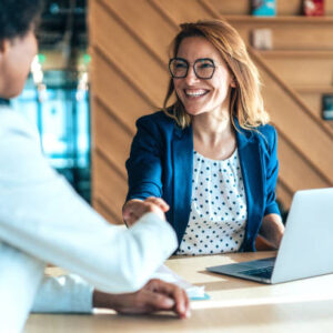 Business people shaking hands in the office. Group of business persons in business meeting. Two entrepreneurs on meeting in board room. Corporate business team on meeting in modern office. Female manager discussing new project with her colleagues. Company owner on a meeting with her employee in her office.